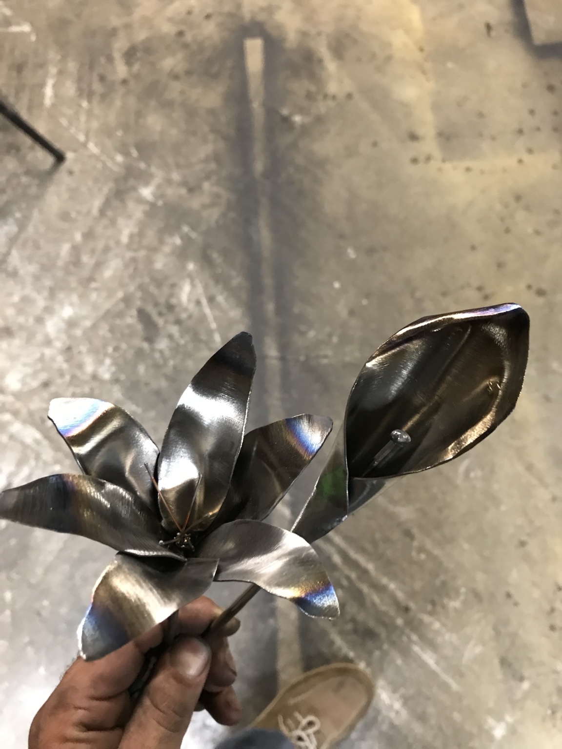 A close-up look at formed metal petals, leaves, and stem.