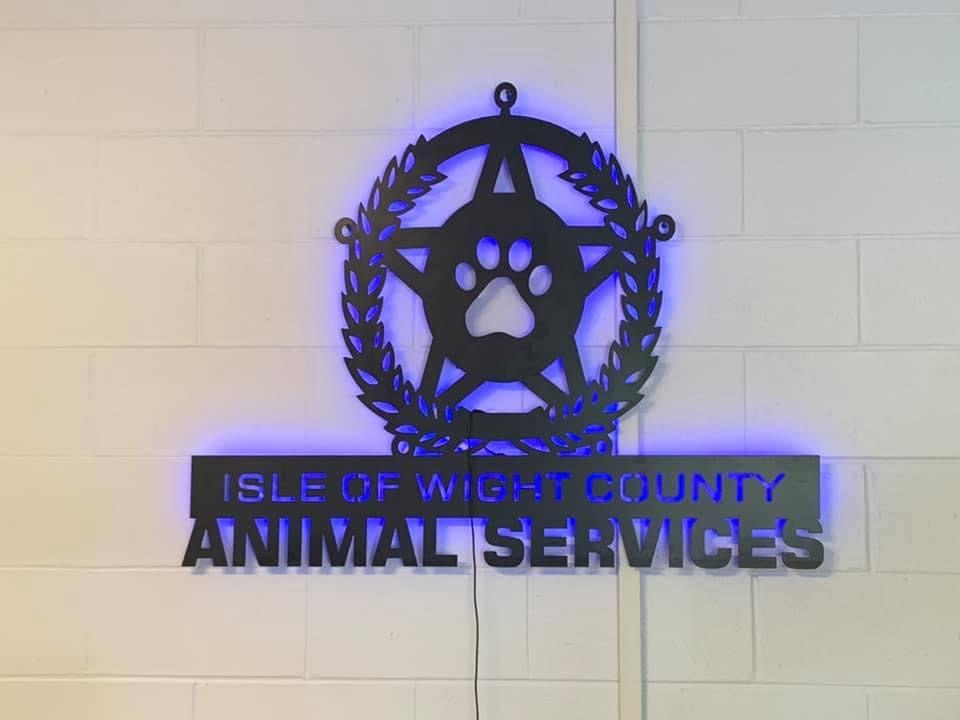 An Isle of Wight County Animal Services sign with blue backlighting.