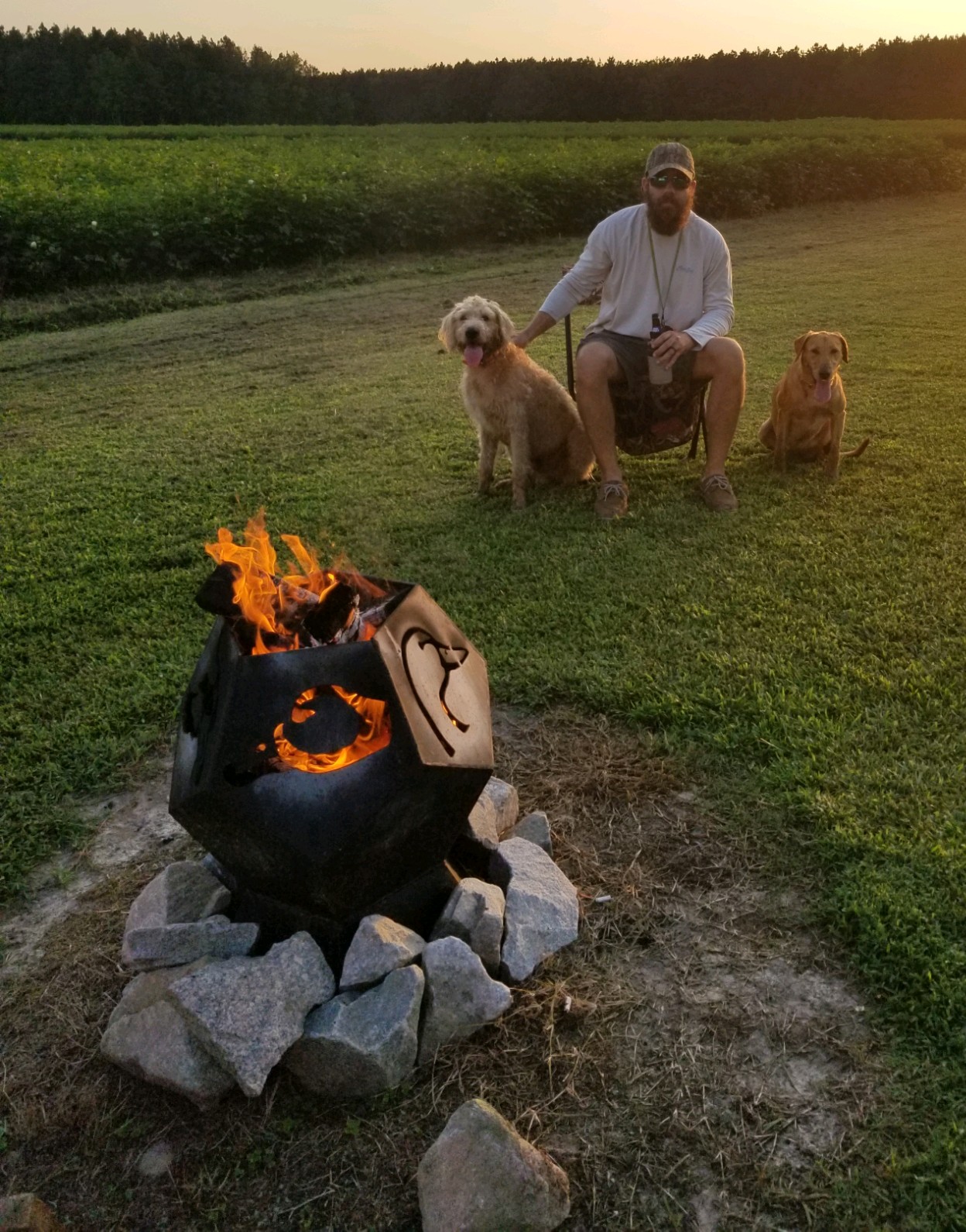 A decorative metal fire pit burning outdoors.