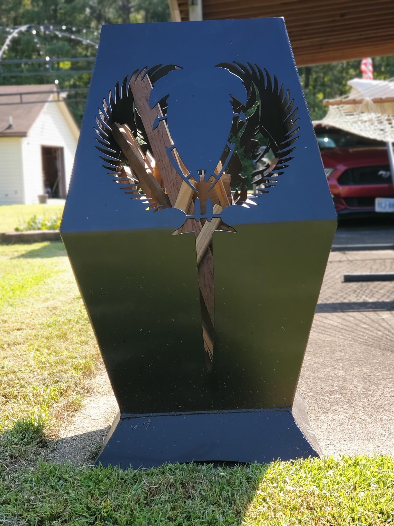 A freestanding metal fire pit with an eagle design.