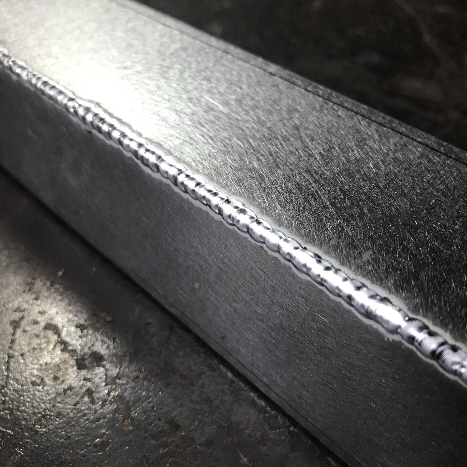 A close-up view of a weld along a metal joint.